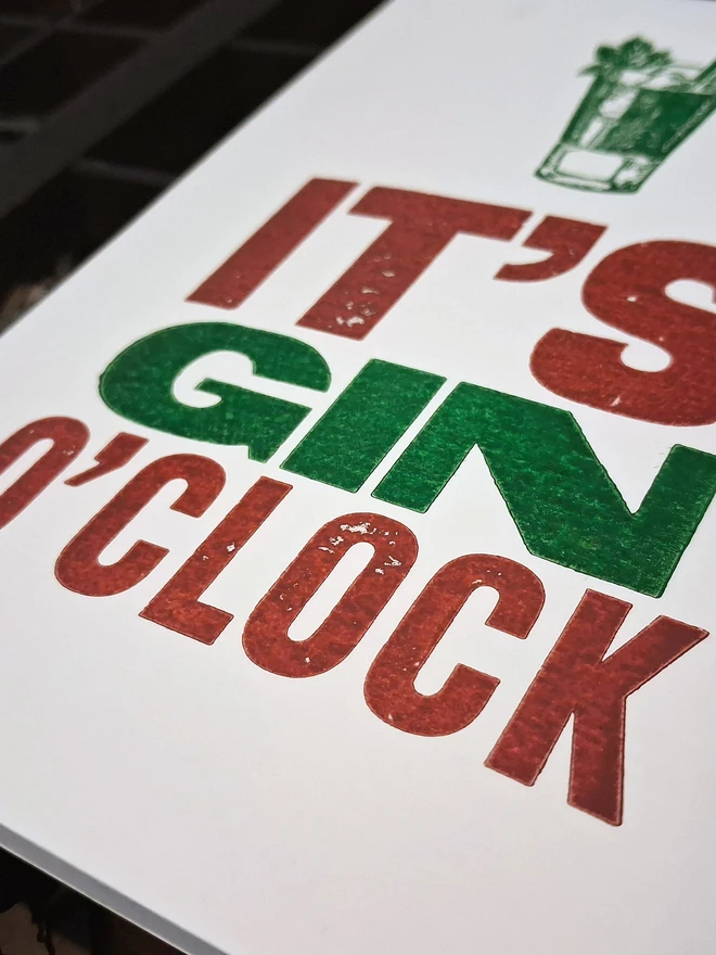 A greetings card printed in burgundy and green with the text 'It's Gin O'Clock'