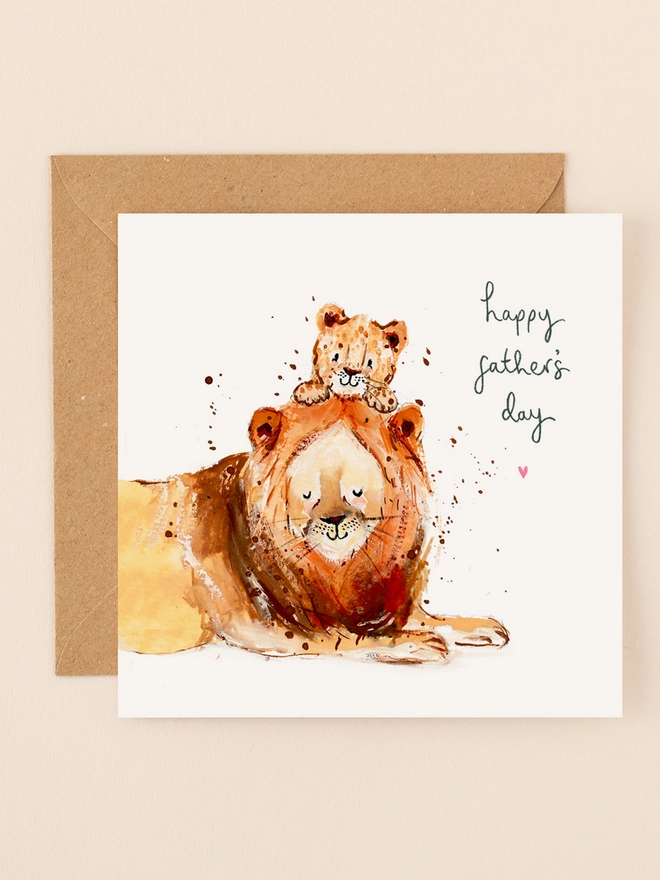 A heartwarming illustration featuring a proud lion and its playful cub, both sporting joyful expressions. The lion's mane is depicted with soft, flowing lines, while the cub gazes up with wide, innocent eyes. Above them, the handwritten message "Happy Father's Day" adds a personal touch. The design combines earthy tones and gentle textures, capturing the warmth and affection of the duo.