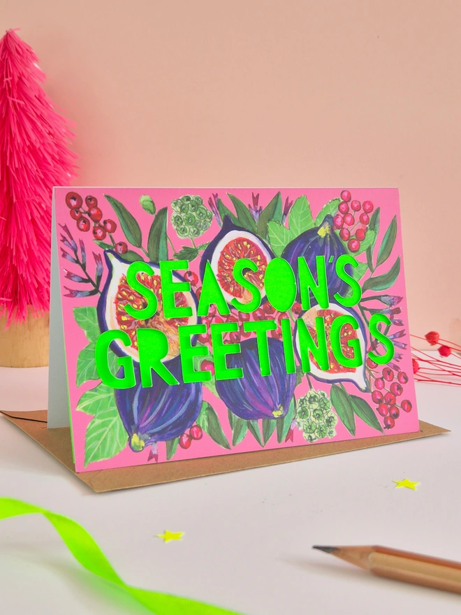 Fig illustration christmas card with season's greeting paper cut text and neon green backing paper 