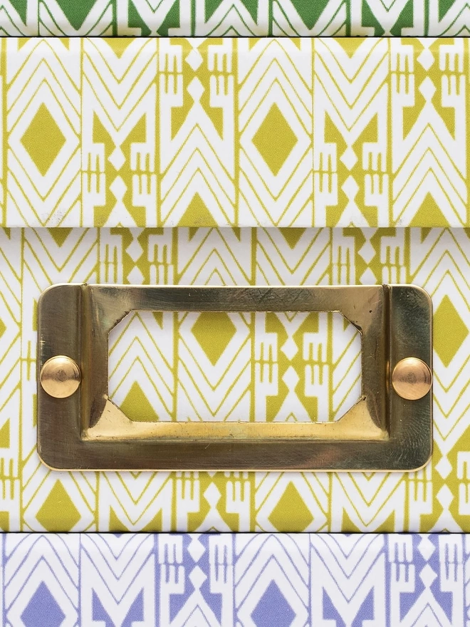 Tijan Lidded Portfolio Box, a collection of colourful portfolio boxes stacked on a plain surface. 