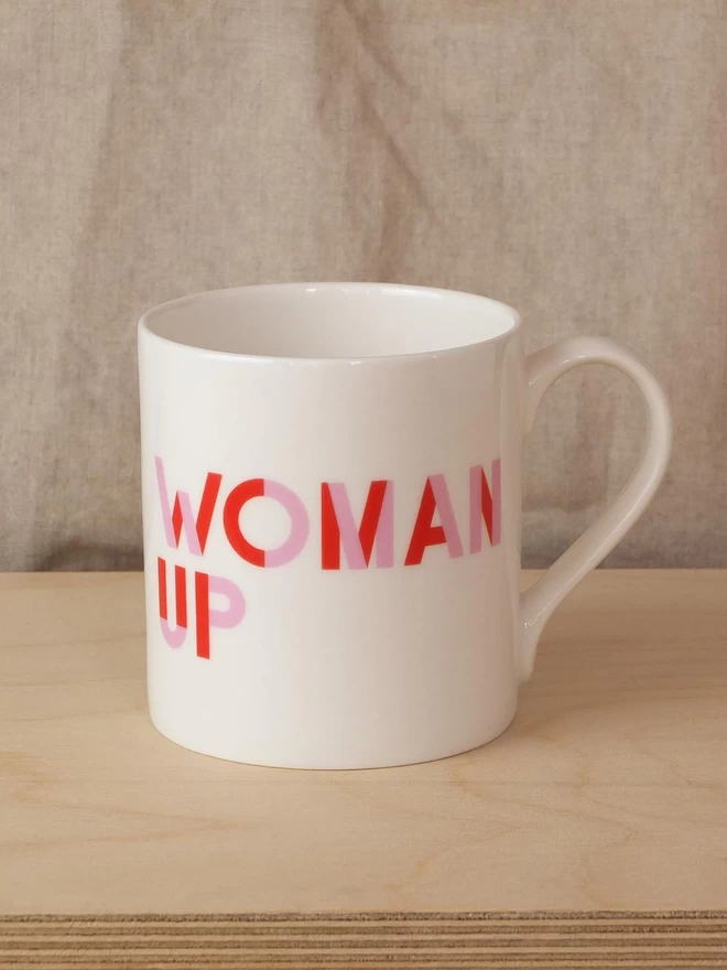 Black & Beech white mug with Woman Up written on both sides in Pink and Red 