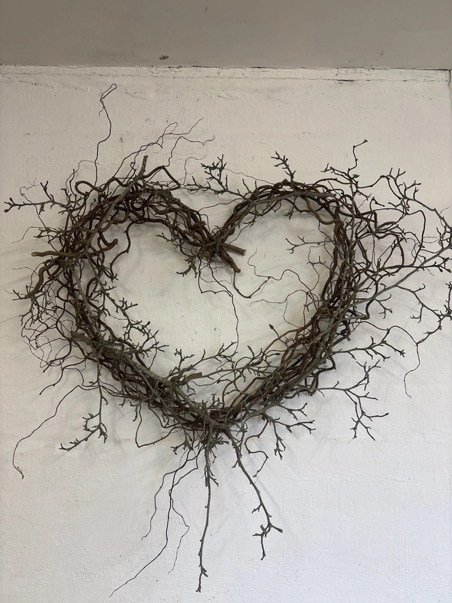 heart shaped wreath made from magnolia branches, hung on wall