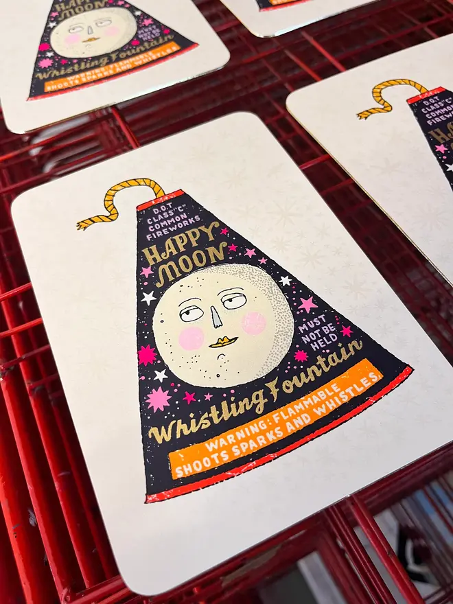 A Flash Of Brilliance Moon Firework Screenprint, a colourful firework design in the centre of a white screenprint. It is placed on a studio rack. 