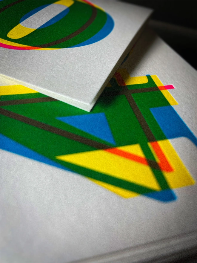 Close-up detail of contemporary handmade letterpress 40th birthday card featuring a bold oversized "50" in a vibrant typographic design. Printed using overlapping cyan, magenta and yellow inks to create striking secondary colours with a deep tactile letterpress impression. Individually hand printed on premium 350gsm GF Smith Colorplan card and paired with a high-quality 135gsm GF Smith Colorplan envelope in a complementary colour. Produced on a beautifully restored 1915 Arab Crown Folio press.
