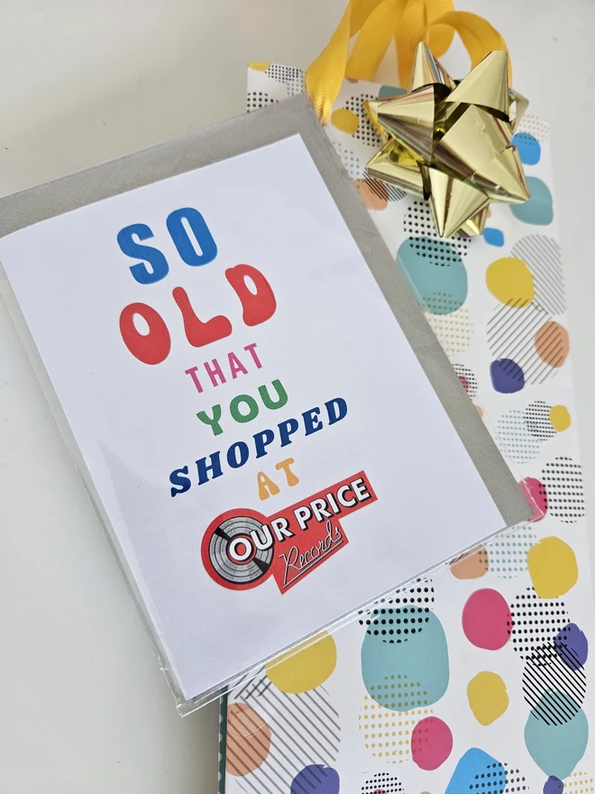 A photograph of the front of a humorous A6 greeting card illustrated using brightly coloured text and the retro shop logo. The text says so old you shopped at Our Price