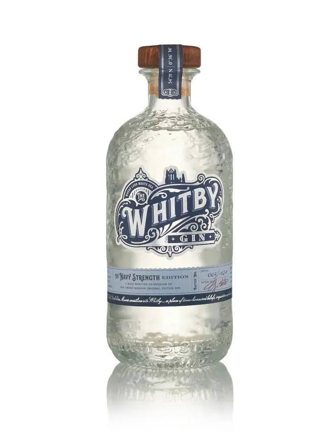 clear bottle of gin with cork lid and blue logo, reading 'whitby navy strength'