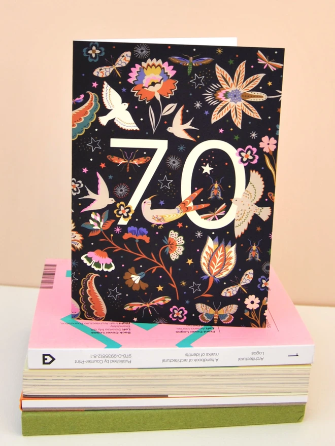 black birthday card with floral and bird designs, with off white "70" 