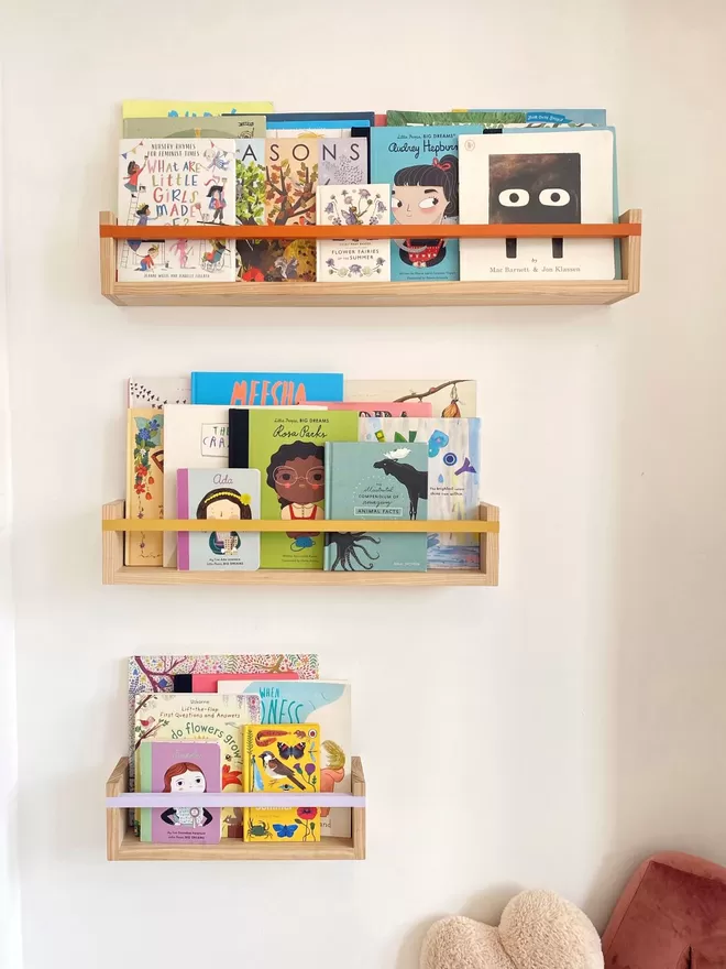 Small, Medium & Large Autumn's Corner handmade bookshelves, with colourful bespoke painted bars. Filled with children's books