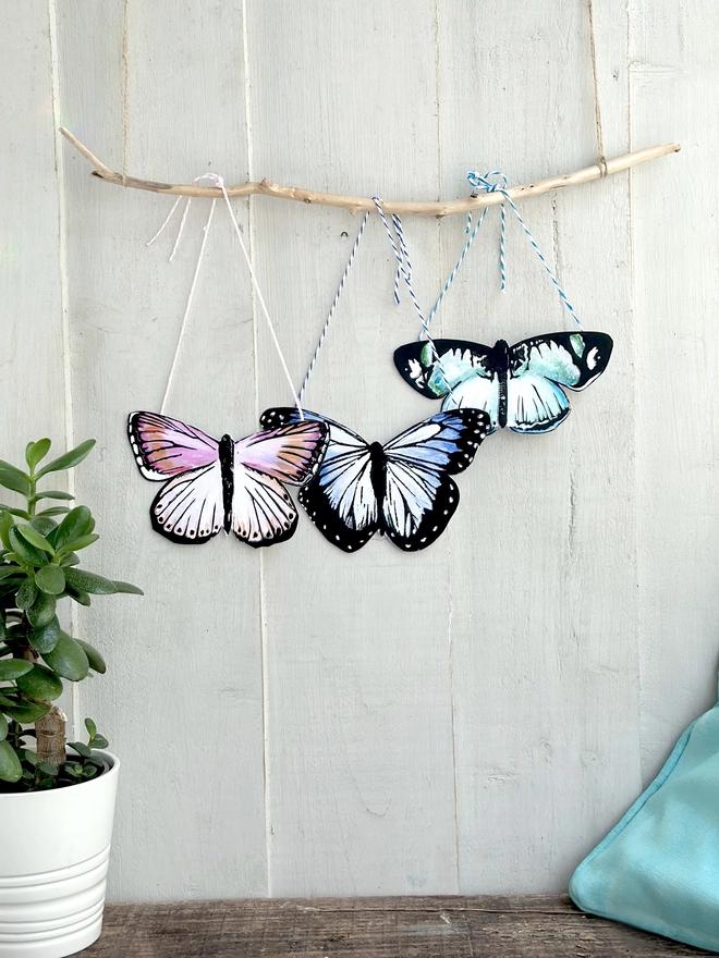 3 Hand Painted Butterflies. Set Of Linocut Wall Hangings displayed on a stick. Colours are pink,purple and pink
