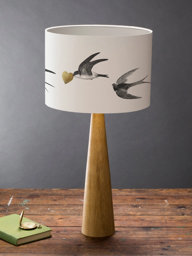 Handmade lampshade featuring graceful flying swallows swooping through a nature-inspired design, adding an elegant touch to any room.