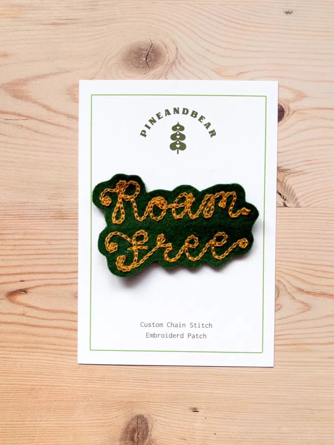 Custom chain stitch patch in green and mustard on a white presentation card