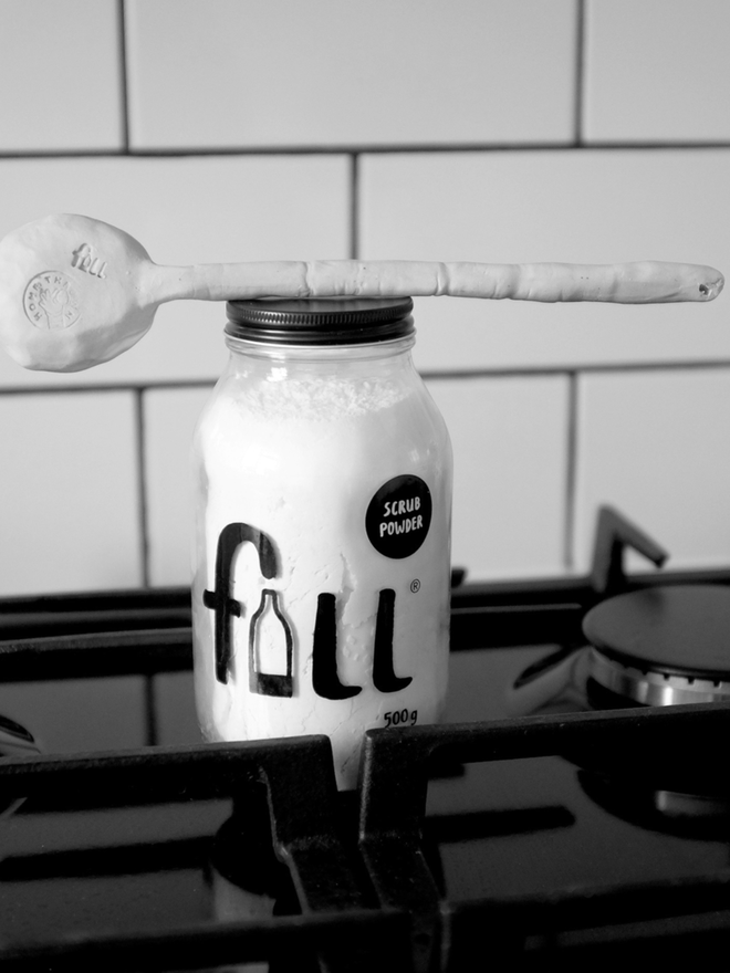 Scrub Powder. A 500g glass jar labelled Fill Scrub Powder. It is placed on a hob.