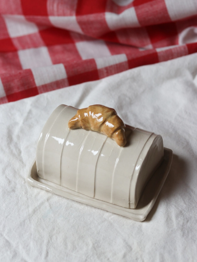 Croissant Butter Dish, a butter dish ceramic sitting on a white tablecloth
