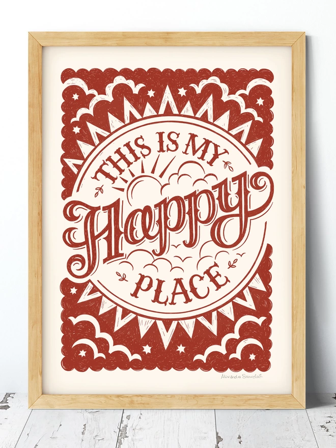 red happy place print in a wooden frame