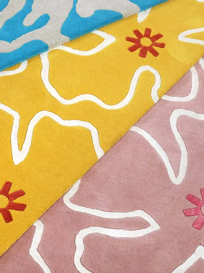 Hibiscus Hand Tufted Rug, a colourful rug on a plain surface. 