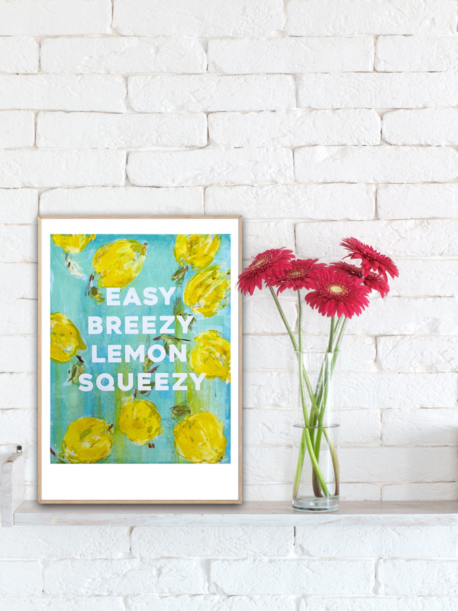 Fine art print by M.E. Ster-Molnar.  EASY BREEZY LEMON SQUEEZY.  Set against a white brick wall and next to gerber daisies.  Oh so cute!  