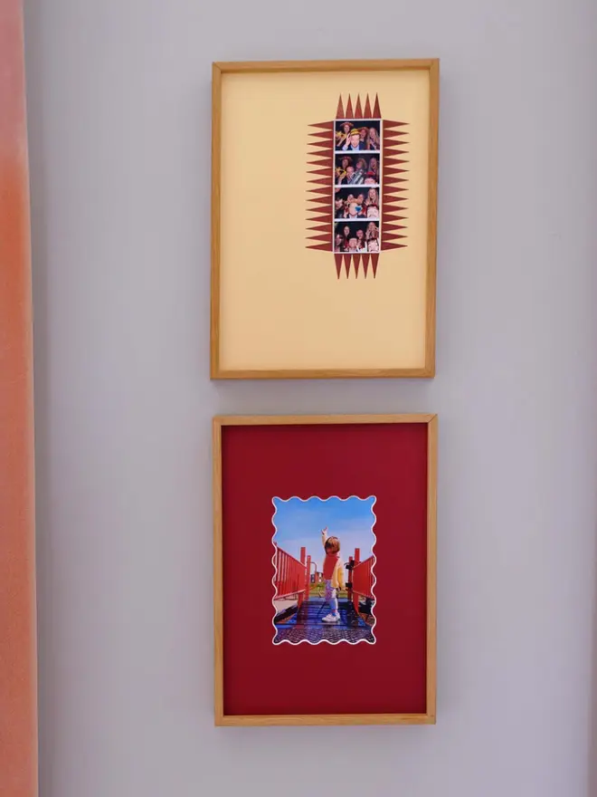 The chevron photobooth mount  frame with a yellow mount featuring a decorative chevron border around a centered Instax photo, displayed on a neutral beige wall.