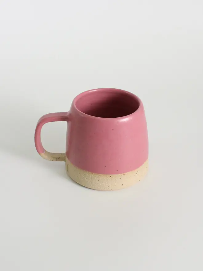 Handmade ceramic fuchsia mug against a white background.