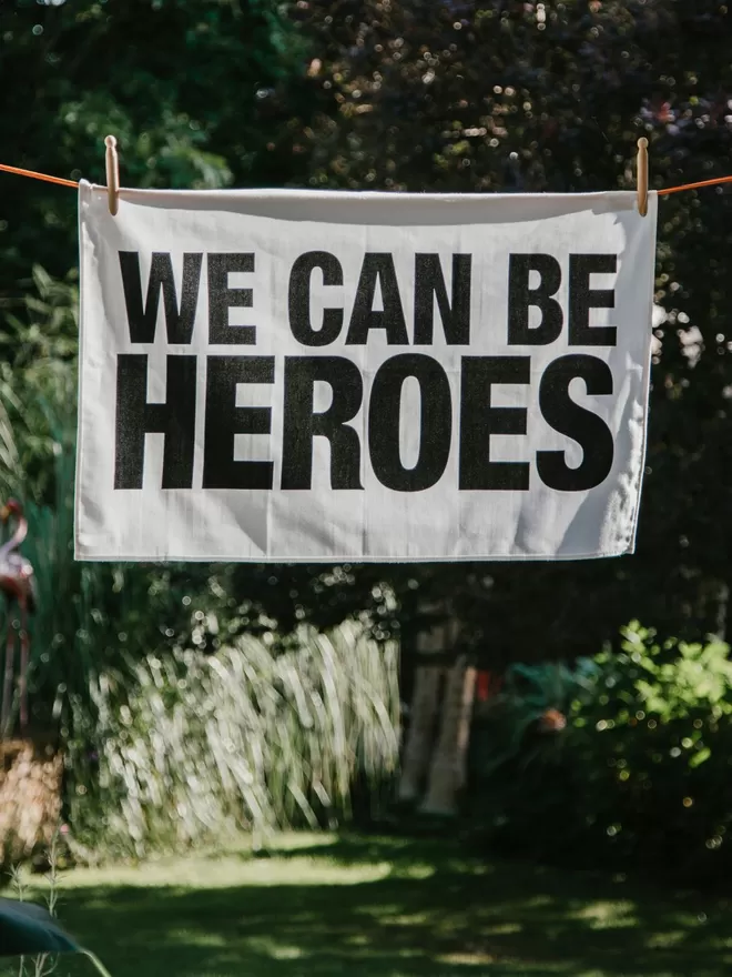 We Can Be Heroes Tea Towel seen on a drying line.