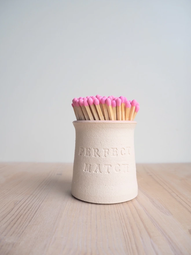 handmade pottery pot to hold matches. perfect match stamped on front, pink tip matches inside pot