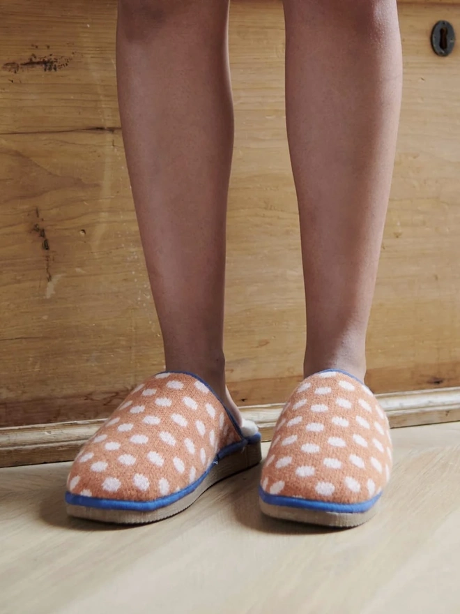 Women's Lambswool & Sheepskin Slippers, a person wearing a pair of colourful slippers indoors. 