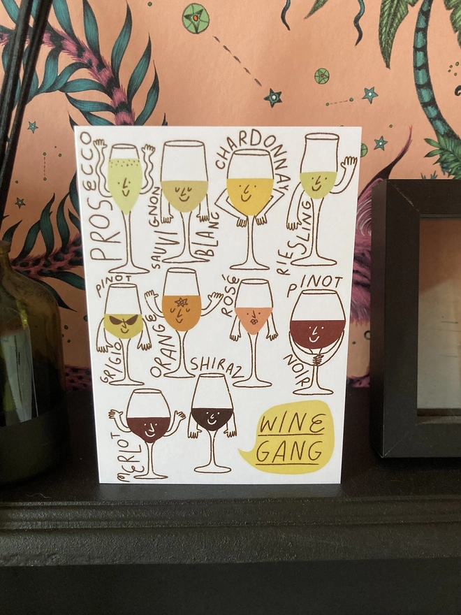Wine gang card on a fireplace, with pink wallpaper in the background