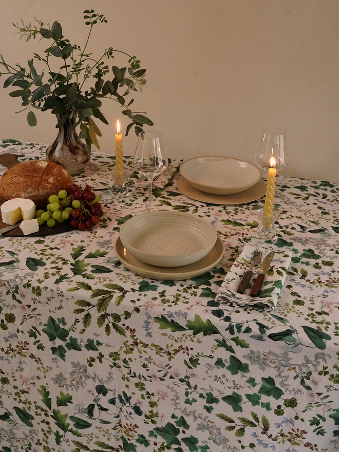 Table laid with linen printed with leaves and flowers