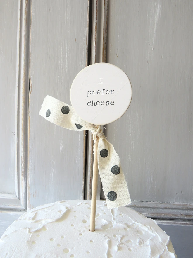 wooden circle shaped cake topper with hand painted message and custom ribbon
