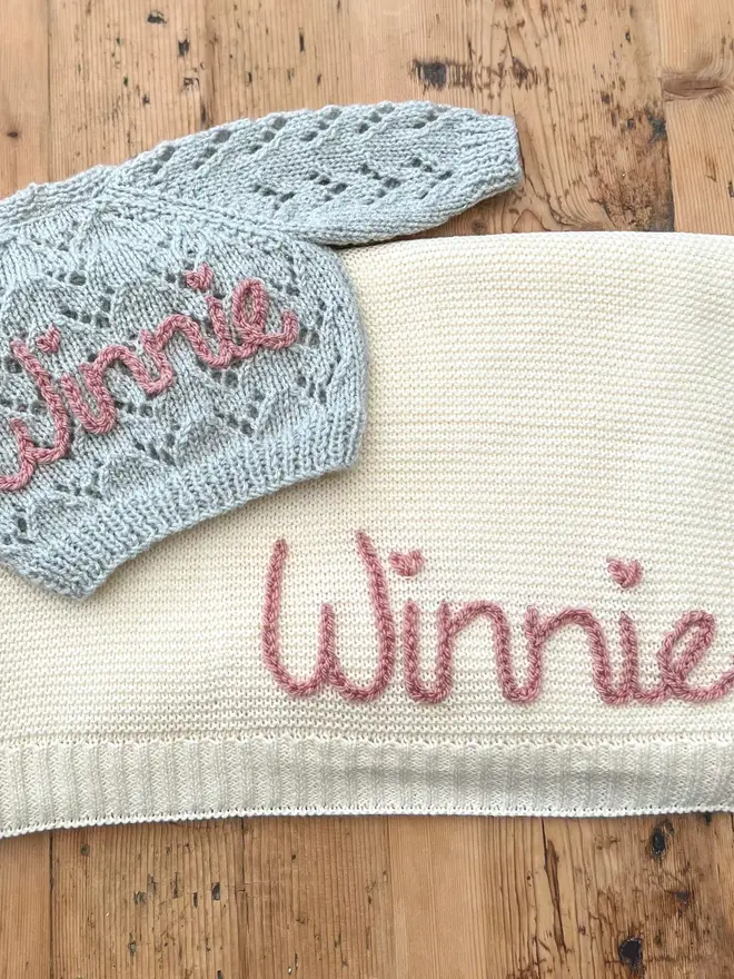 Hand Embroidered Baby Blankets, a hand embroidered blanket sitting on a wooden surface. 