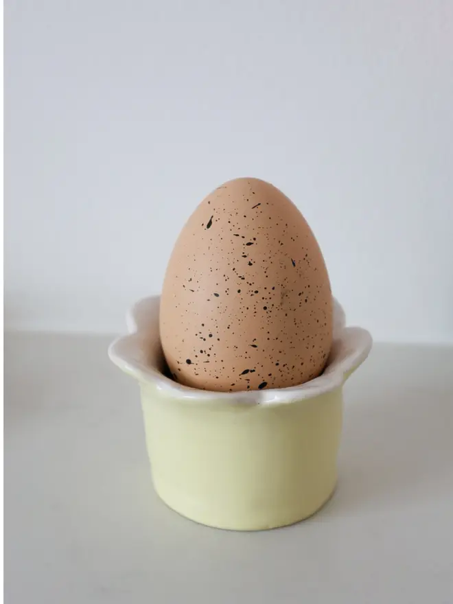 Yellow ceramic Daisy egg cup, perfect for morning eggs.