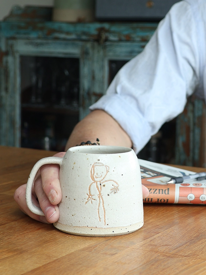 Childrens Drawing Handmade Ceramic Mug
 held on wooden table