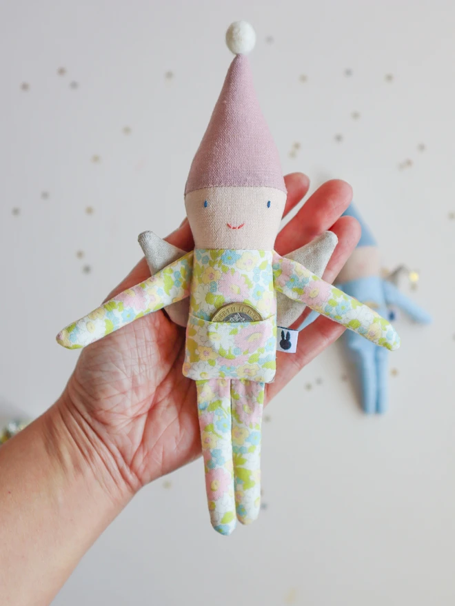 Small fairy dolls in blue and pink linen pointy hat, blue star and pink floral printed outfit and natural linen wings.