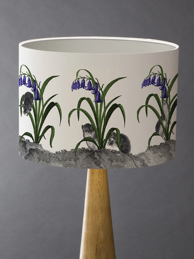 A whimsical lampshade featuring adorable mice hiding among bluebells, creating a charming woodland-inspired design.