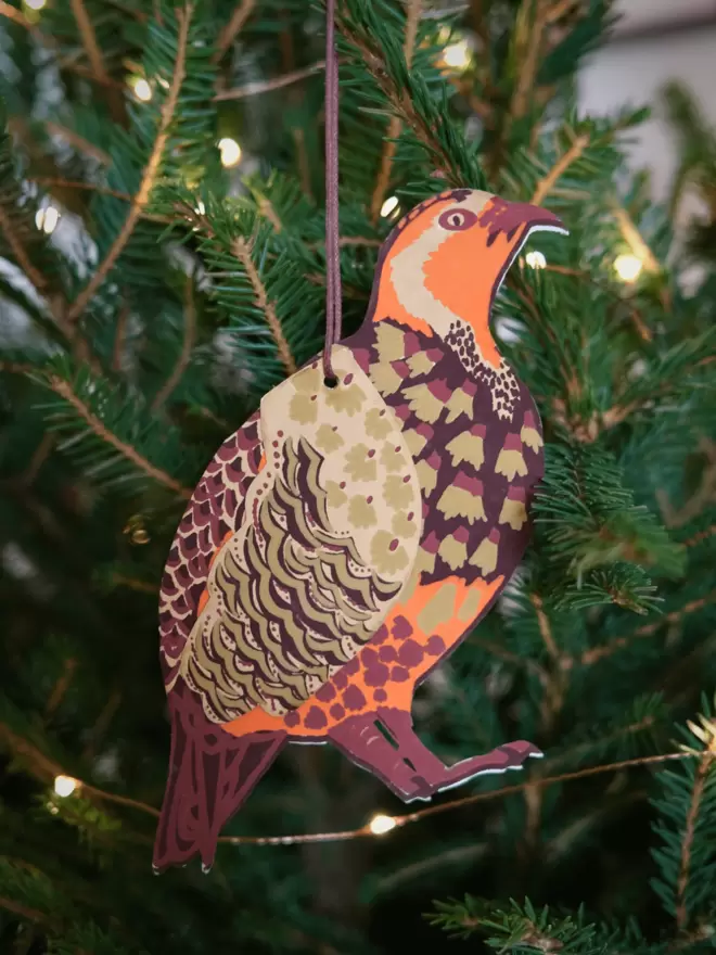 Winter bird with green Christmas tree and twinkling lights in background