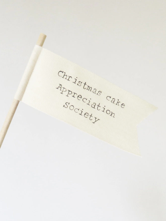organic cotton flag with hand painted festive message wrapped round wooden dowel.