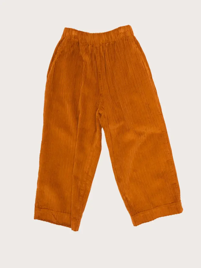 Front flat lay of Studio Koter Ever trousers in umber corduroy, wide-leg with an elasticated waist and side pockets.