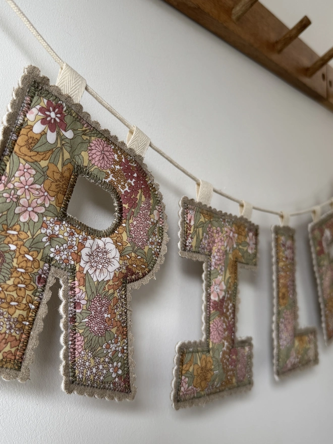 Fabric Letter Garland.  Close up of a fabric letter in pinks and green florals