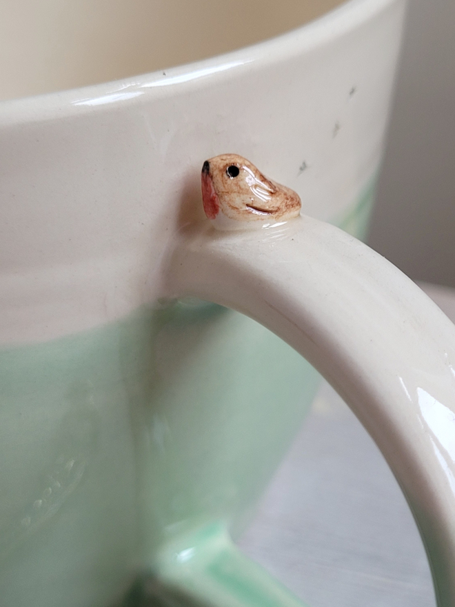 ceramic green cup with tiny robin bird on the handle and birdprints