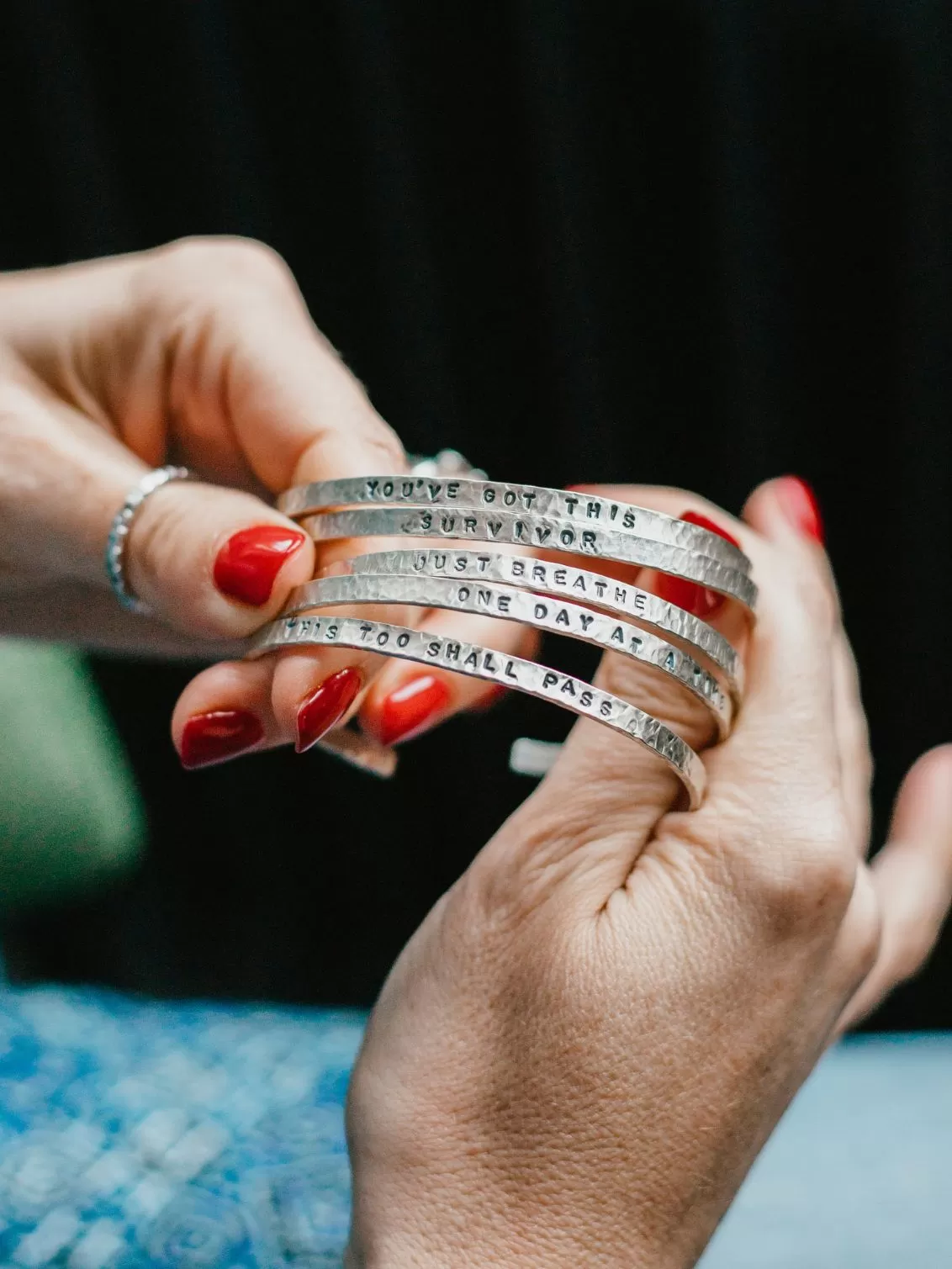 Willow and Twig sterling silver empathy bracelets seen held by someone with red nails.