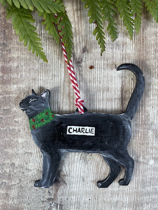 Black Cat Hand-painted personalised Christmas decoration with the name Charlie and hung with red velvet ribbon