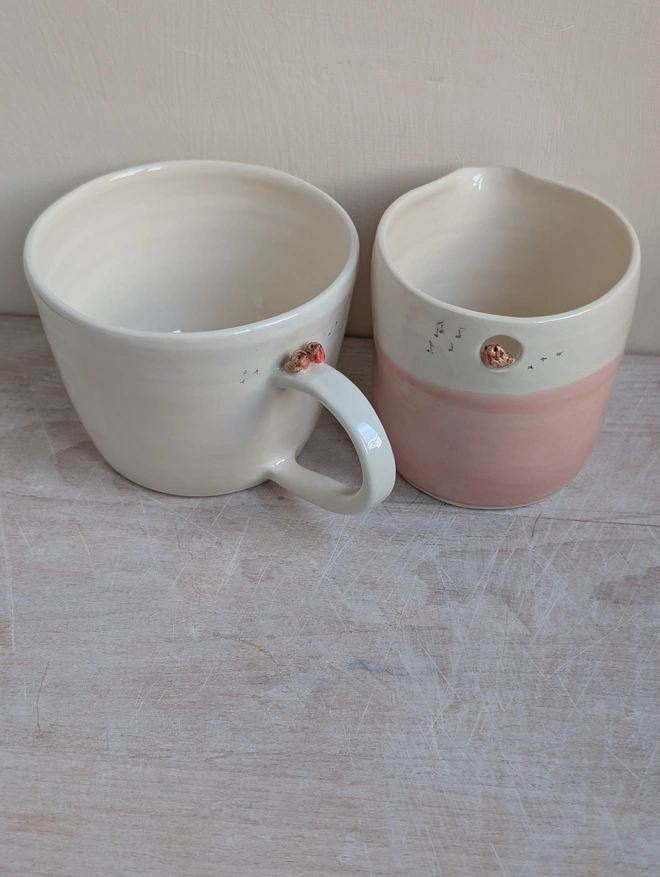 robin couple mug with a tiny pair of robin red breast birds on the cup handle and small bird prints on the white cup next to a pink and white robin jug