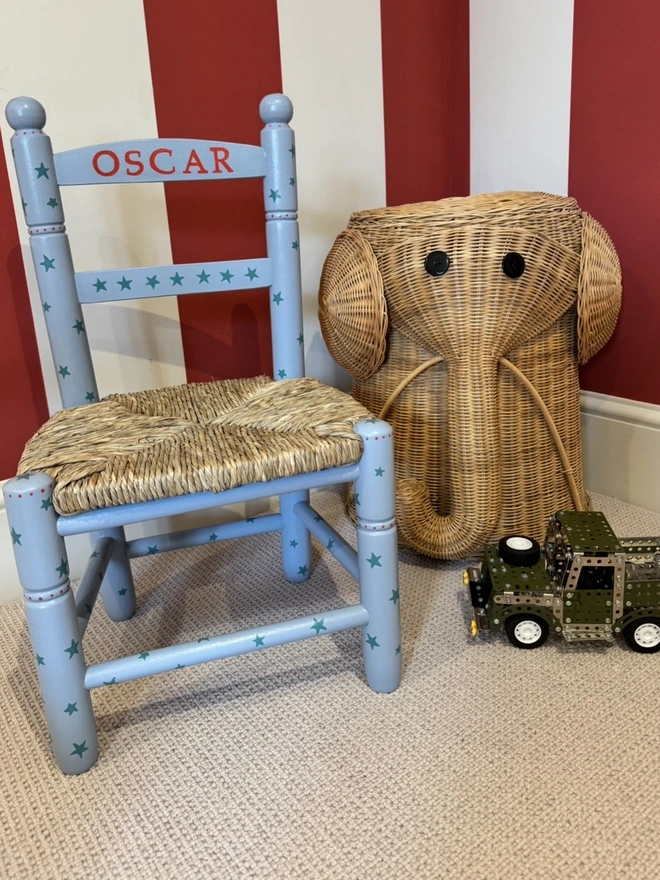 Nursery with a wooden chair painted in blue personalised with the name Oscar. 