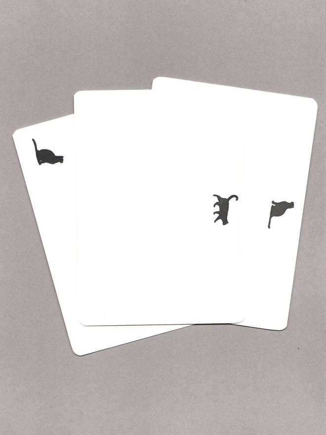 Three notecards with black cats laid out on a grey background