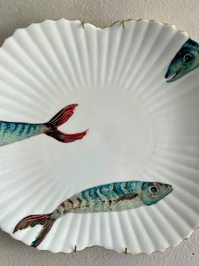 Fine Art Oil Painted Three mackerels On A vintage Plate, hanging on a white wall.