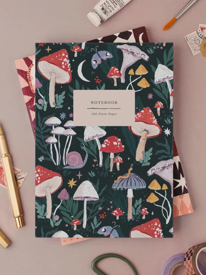 Mushrooms Notebook with a gold pen and art supplies