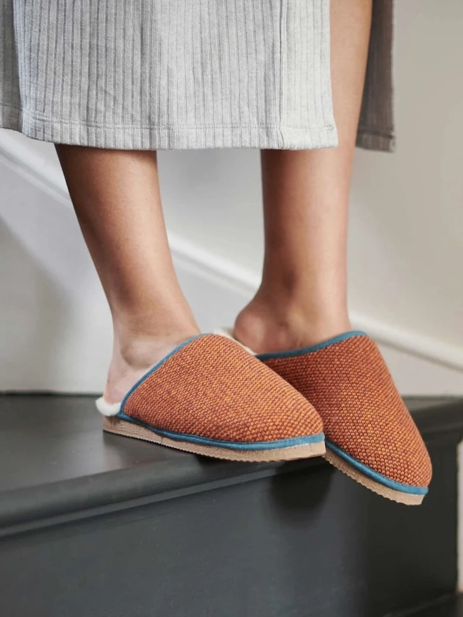 Women's Lambswool & Sheepskin Slippers, a person wearing a pair of colourful slippers indoors. 