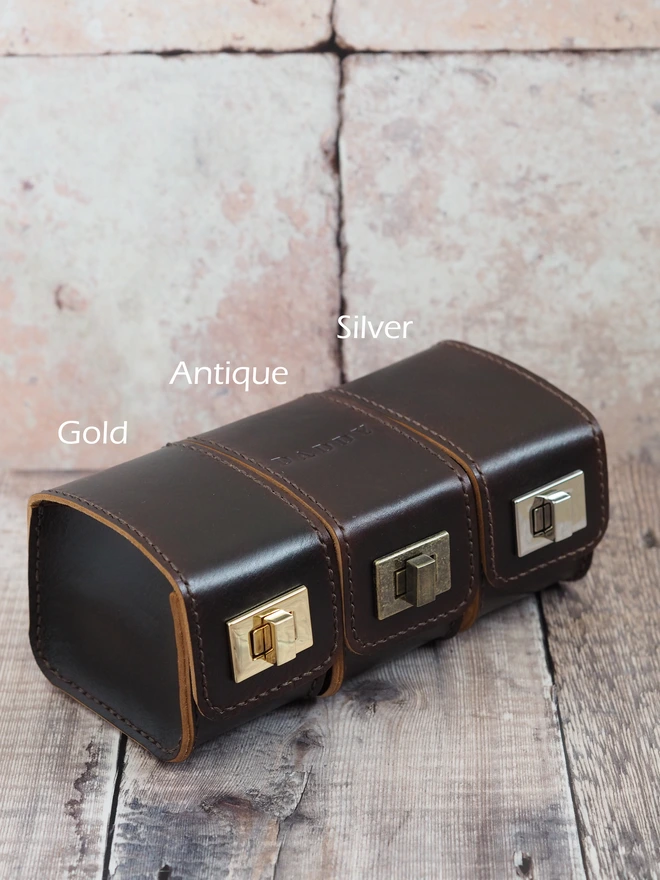 Personalised Leather Watch Case. Handmade leather watch carry case. Three cases sit together, each with a different coloured clasp, gold, antique and silver.