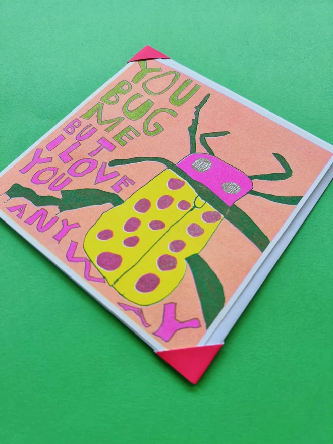 A close up of colourful humorous card featuring a bug with the words You Bug Me But I Love You Anyway