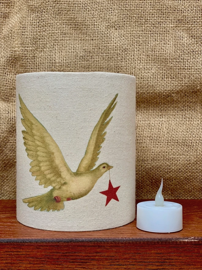 Tealight holder with a dove carrying a red star