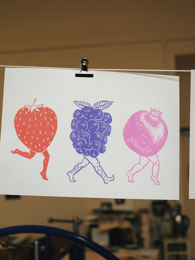 A print showing 3 fruit with legs walking across a page